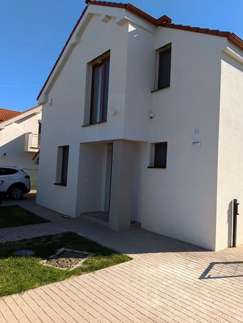 Biely dom s drevenými oknami zo záhrady