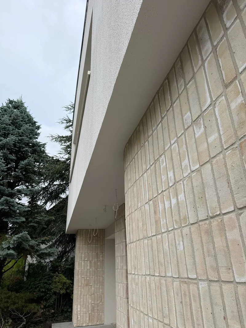 Detail tehlového obkladu na zaoblenej stene pod presahom poschodia