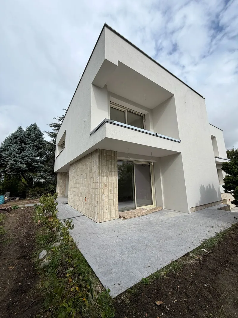Roh domu s lodžiou na poschodí, tehlovým obkladom a dlažbou terasy