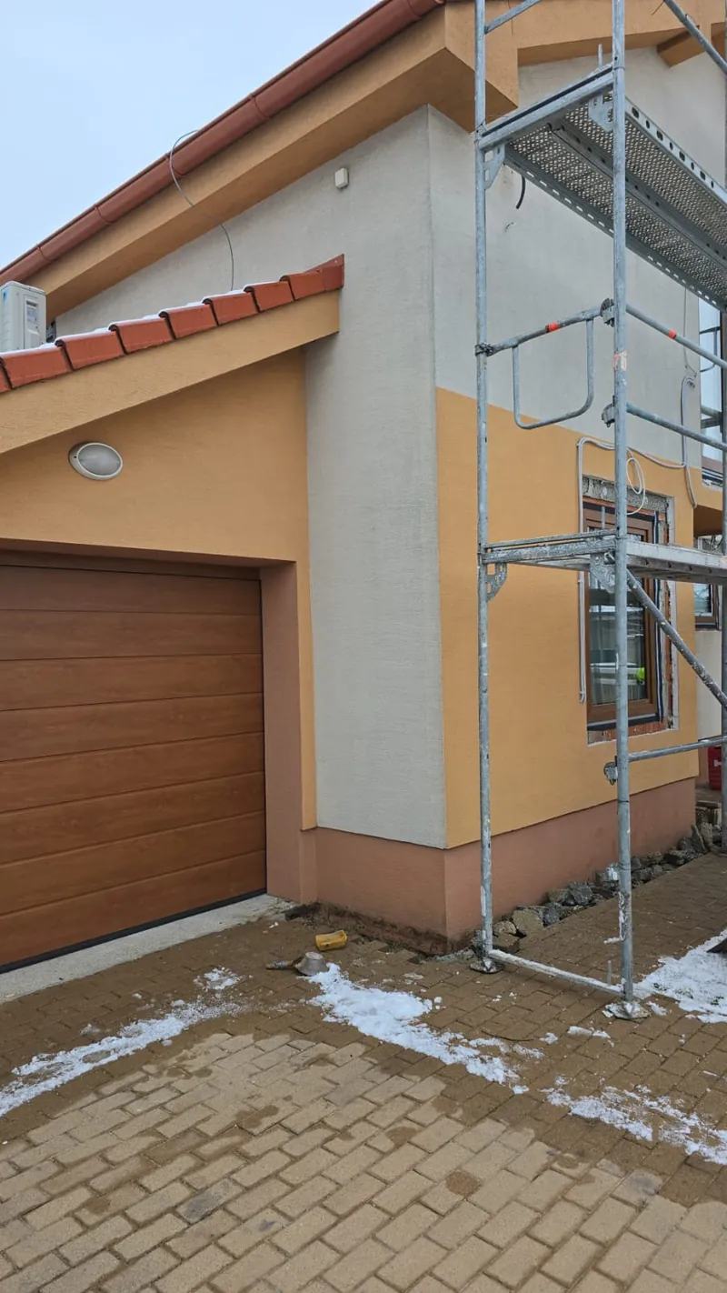 Garáž s pôvodnou oranžovou fasádou a postaveným lešením